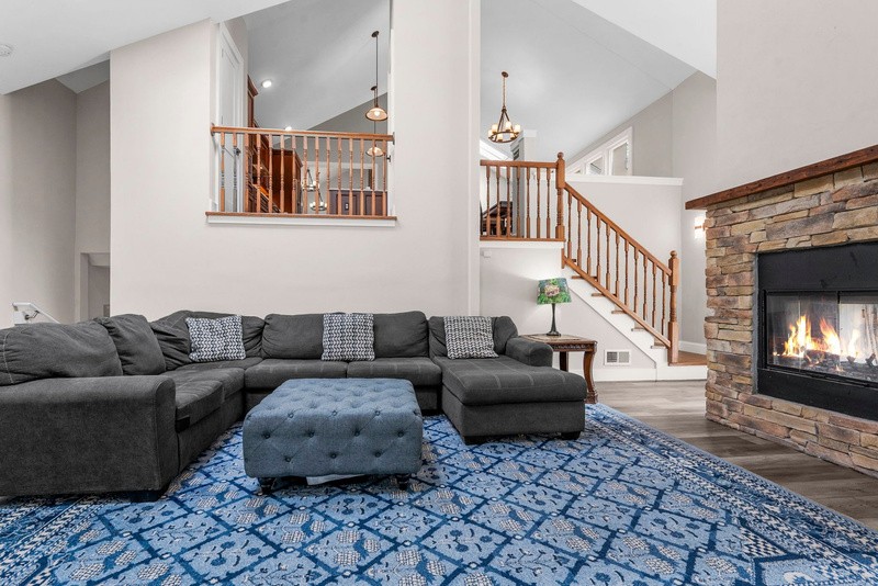 Great room with stone fireplace under vaulted ceilings